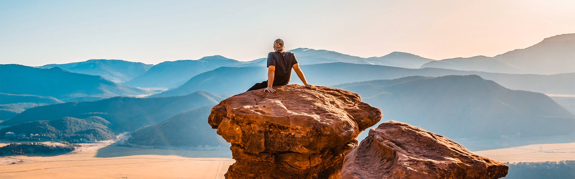 Mann sitzt auf Felsen, in die Ferne blickend |  Unsplash, Jamie Fenn / Chamleon